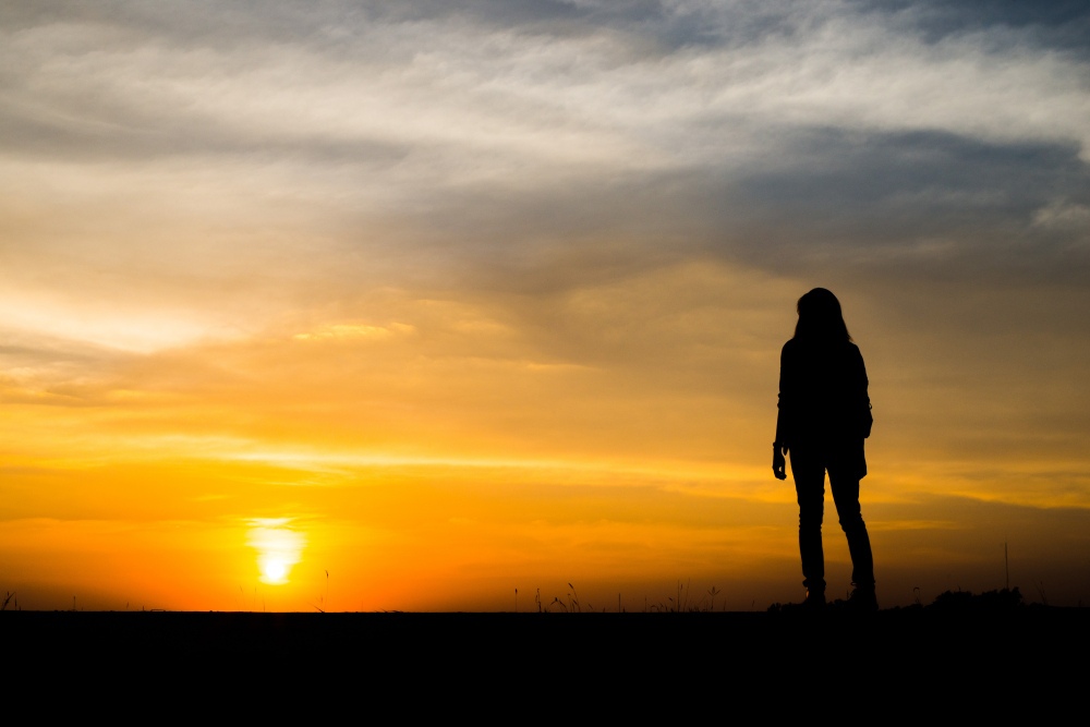 A silhouette of a person standing at a crossroads, symbolizing the journey to healing.