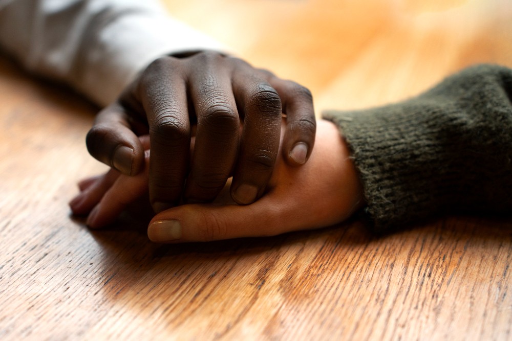A comforting hand on someone’s shoulder, symbolizing support in grief.